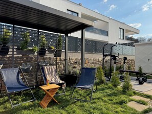 A modern outdoor patio with a covered seating area, exercise equipment, and potted plants. - Infinity Haven Residence – Holiday home with pool & outdoor gym (Milčetići)