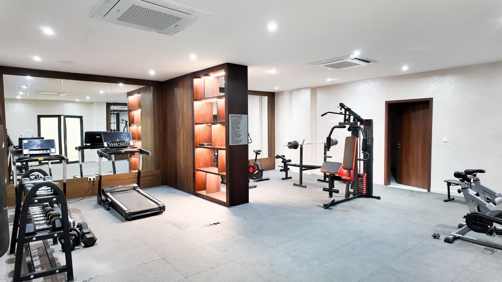 Ein Fitnessraum mit Cardiogeräten, Gewichten und Laufband.