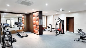 A gym with cardio machines, weightlifting equipment, and a treadmill. - Peravi at The Essence  (Accra)
