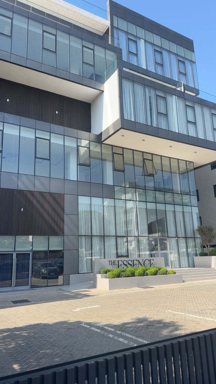 A modern building with large glass windows, a flat roof, and a sign reading 'THE SENSE'.