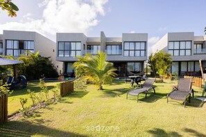 A modern hotel with a courtyard featuring outdoor seating and palm trees. - House by the sea With Pool and Barbecue Gre0040 (Passo de Camaragibe)