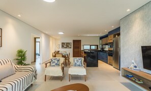A modern living room with a sofa, two chairs, a coffee table, and a dining area with a table and chairs. - House in Arraial D'ajuda With Pool Pcr0006 (Porto Seguro)
