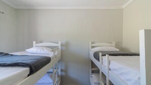 A room with two bunk beds, each with a pillow and a blanket. - House in Cond. w/ Pool - Cabo Frio Vdp0029 (Cabo Frio)