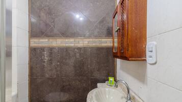 A bathroom with a sink, mirror, and a wooden cabinet.