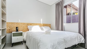 A modern bedroom with a bed, nightstand, and built-in shelving unit. - Fit w/ Beautiful View of Lagoa da Conceicao Sdr002 (Florianópolis)