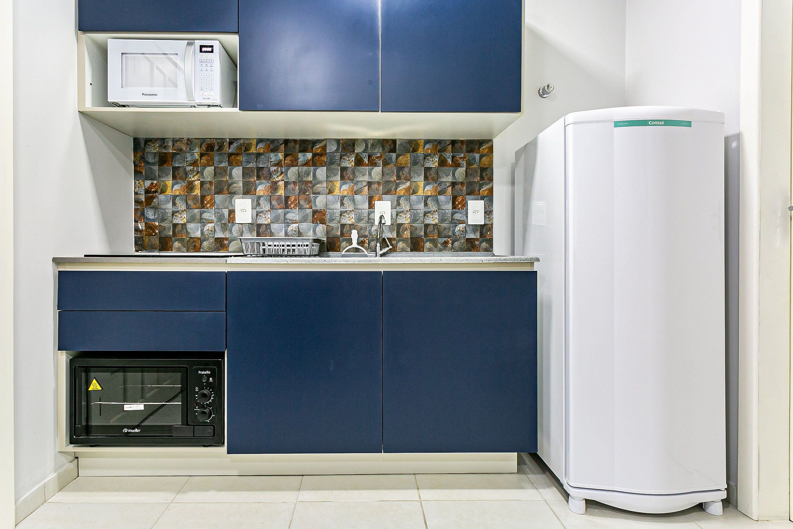 A compact kitchen with a microwave, toaster, and refrigerator.