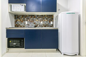 A compact kitchen with a microwave, toaster, and refrigerator. - Decorated Studio Facing the Lagoon Sdr009 (Florianópolis)