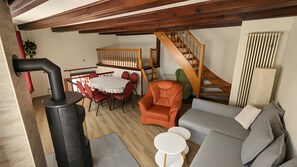 Una sala acogedora con chimenea, comedor y escalera.