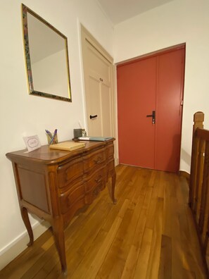 A wooden dresser with drawers, a mirror, and a small table with stationery items. - Beautiful apartment just a stone's throw from downtown, with a parking space (Blois)