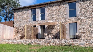 Edifici de pedra amb un pati, seients a l'aire lliure i vista al cel.