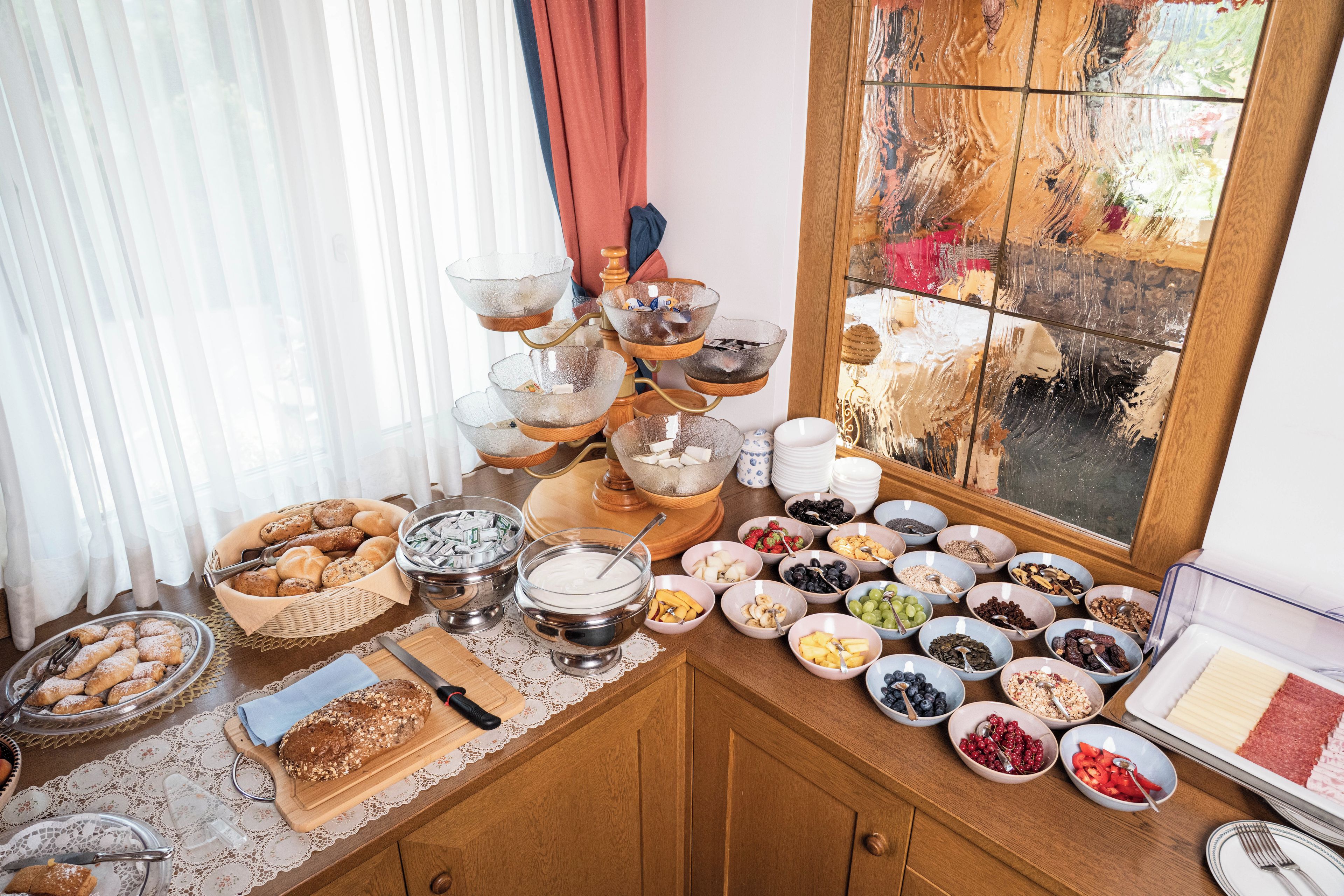 Un bufé de desayuno con diversas opciones de comida y una vista decorativa a la ventana.