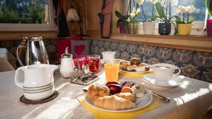 A breakfast table with a pitcher, teapot, cups, and pastries.