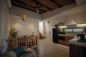 A spacious kitchen with a dining area, wooden ceiling beams, and a modern stove. - SEN House Hoi An - 2 Bedrooms with Pool, Kitchen and Rooftop (Hoi An Tay)