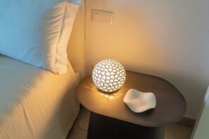 A bedside table with a spherical lamp and a white object beside it. - Villa Curreli – Authentic Sardinian Charm (Sardegna)