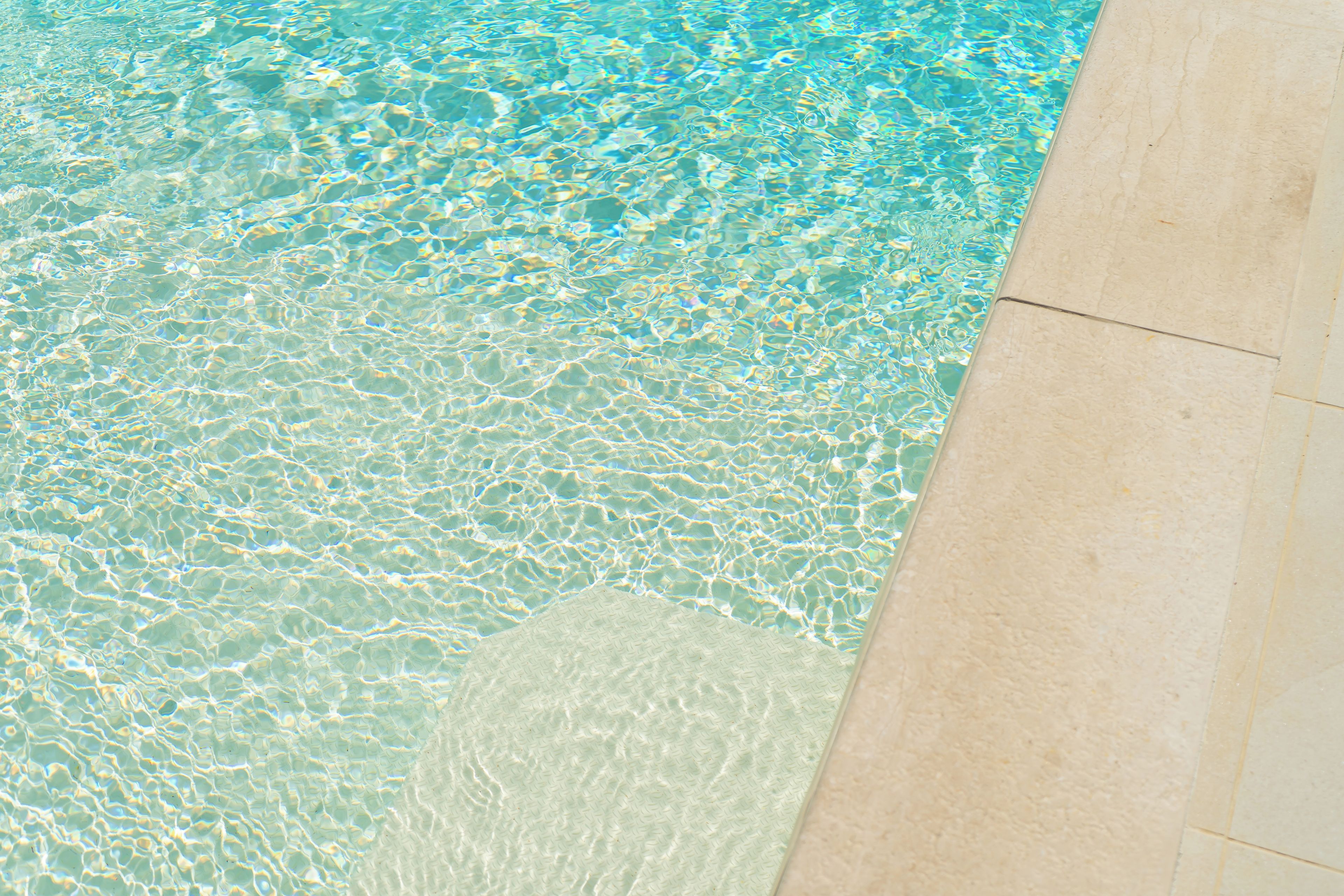 A pool with clear water and a tiled edge.