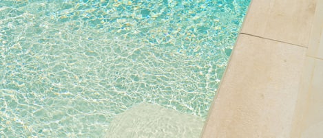 A pool with clear water and a tiled edge.