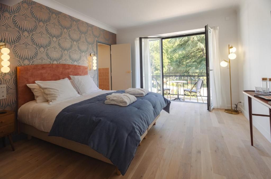 Een slaapkamer met een bed, nachtkastje en uitzicht op de omgeving.