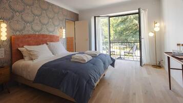 Een slaapkamer met een bed, nachtkastje en uitzicht op de omgeving.
