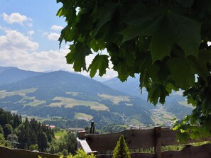 Une vue panoramique d’un paysage montagneux, avec un banc en bois au premier plan.