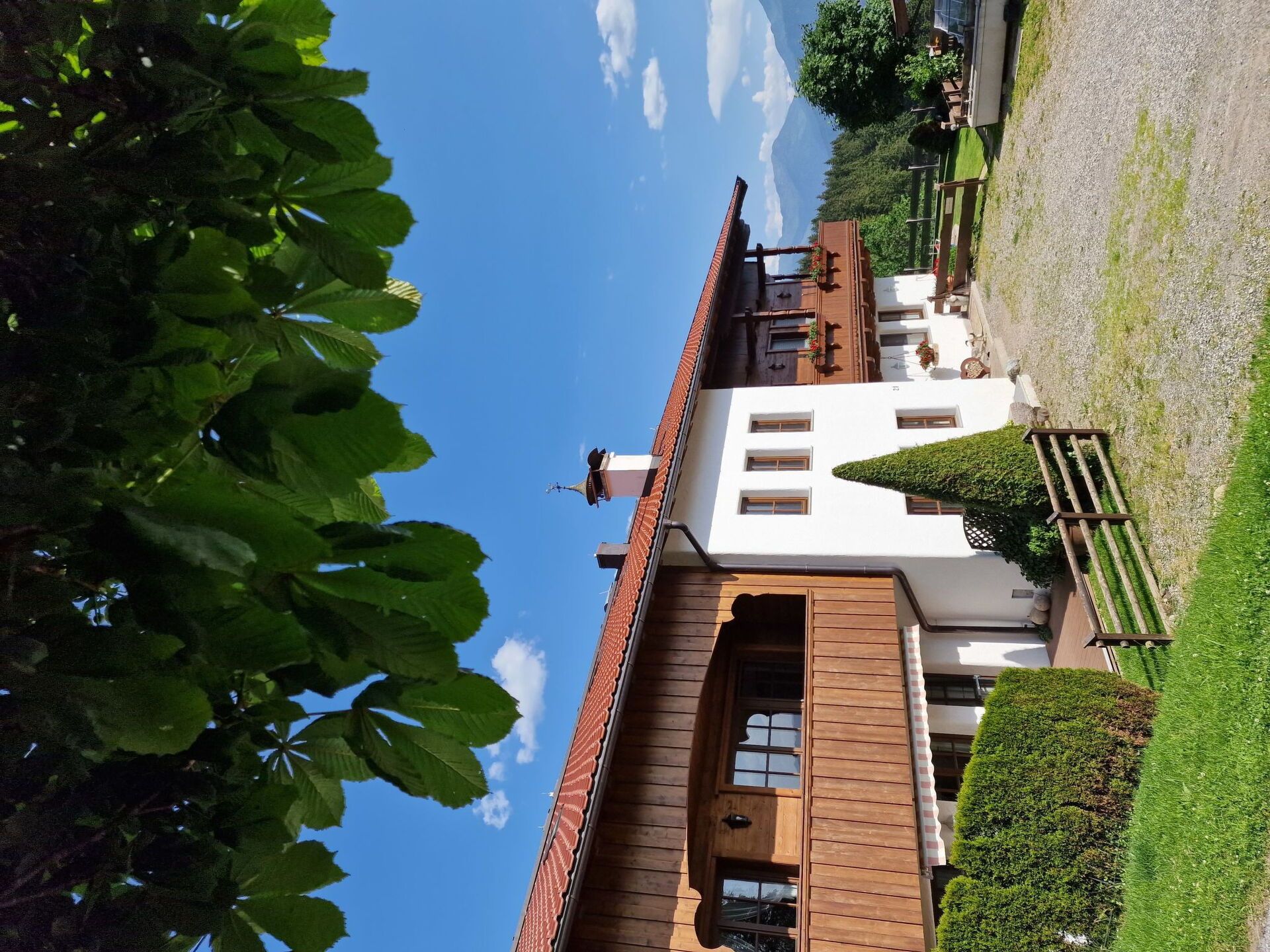 Un bâtiment traditionnel avec un toit en pente, une façade en bois et un ciel dégagé en arrière-plan.