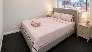 A bedroom with a bed, bedside lamps, a window, and a view of the outside. - Luxury Family Retreat in Chipping Norton (Chipping Norton)