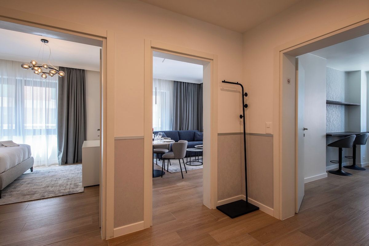 Een hotelkamer met een bed, een bureau, een stoel en een zithoek met een tafel en stoelen.