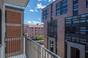 Ein modernes Gebäude mit einem Balkon mit Blick auf eine Straße und weitere Gebäude.