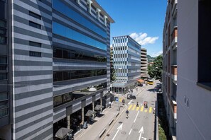 A multi-story urban building with a modern architectural style, featuring a mix of glass and concrete facades. - Boutique Suites Two Bedroom Apartment with AC (Lugano)