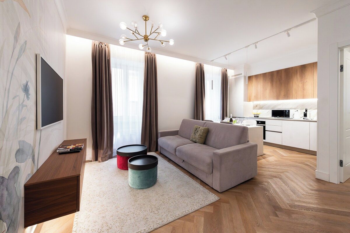 Una sala de estar moderna con un sofá, una mesa de centro y un televisor de pantalla plana.