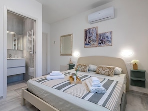 Ein Hotelzimmer mit Bett, Bad und einer wandmontierten Klimaanlage.