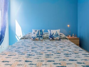 A bedroom with a bed featuring a nautical theme, including fish and sea creatures on the bedding. - Nice apartment for 6 people with WIFI, A/C, TV and patio (Alghero)