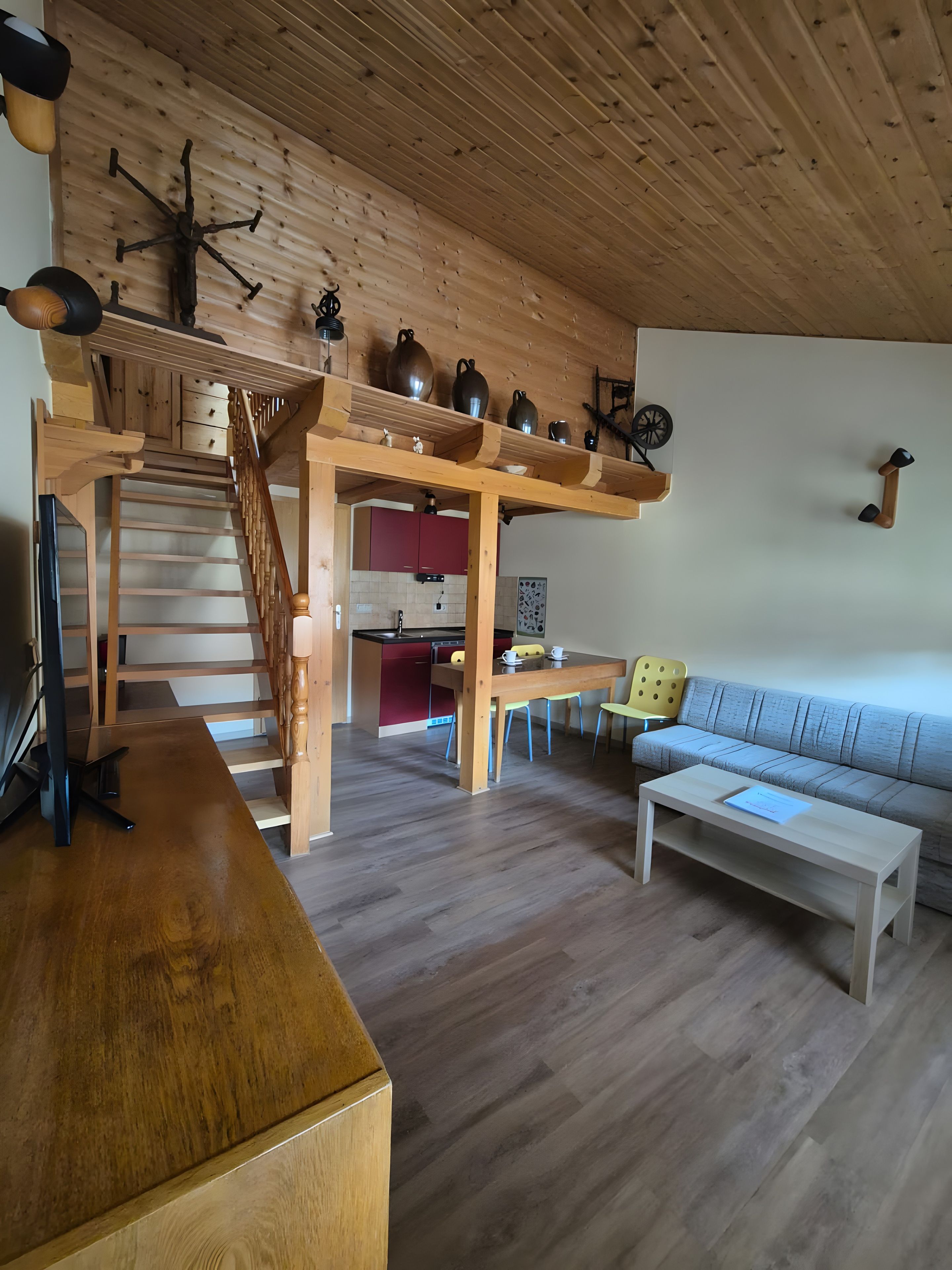 Un intérieur en bois avec un escalier, un coin repas et un canapé.