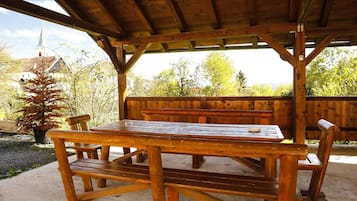 Een houten terras met banken en een picknicktafel.