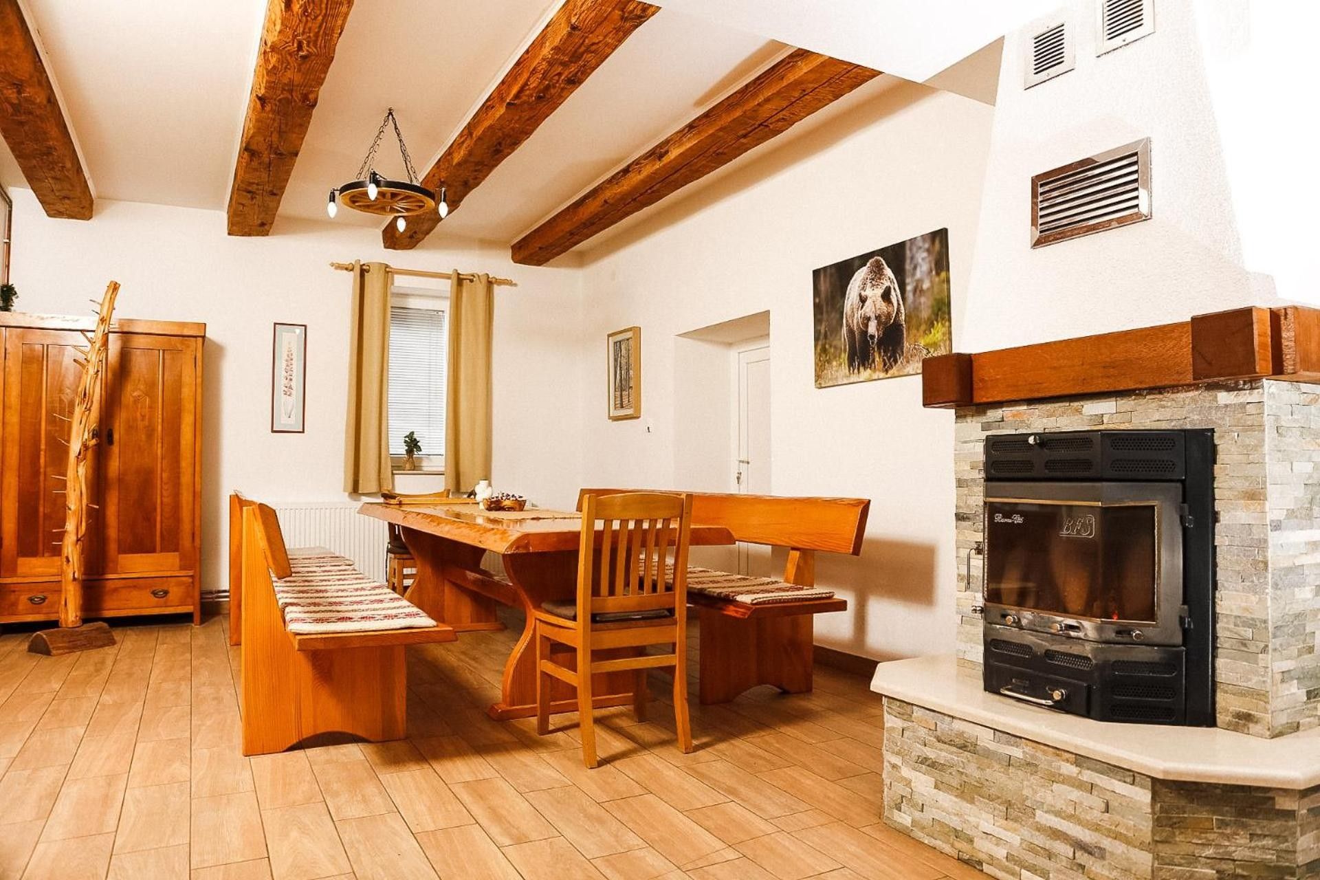 Un espace repas avec des meubles en bois, une cheminée et un mur d’accent en pierre.