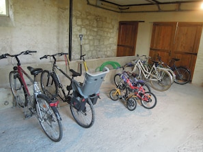Bicicletes aparcades a l'interior, amb sòl de formigó i parets de pedra.