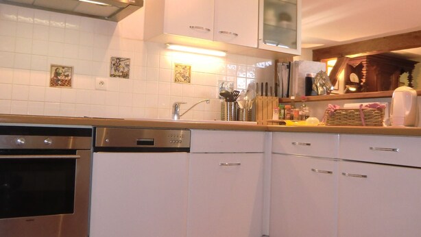 A kitchen with white cabinets, a stainless steel oven, and a dishwasher.