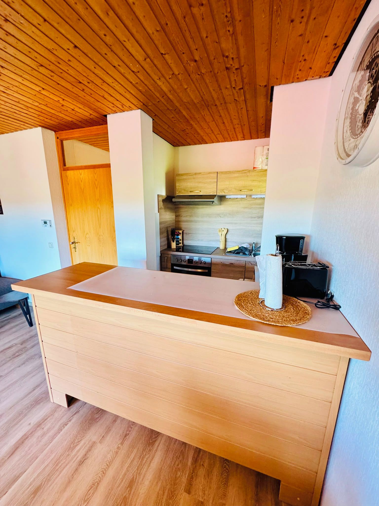 Eine Küche mit Holzschränken, einer Arbeitsplatte und einer Kaffeemaschine.