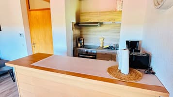Eine Küche mit Holzschränken, einer Arbeitsplatte und einer Kaffeemaschine.