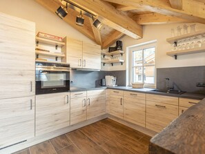 Una cocina moderna con armarios de madera, horno empotrado y ventana que proporciona luz natural.