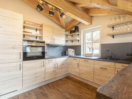 Una cocina moderna con armarios de madera, horno empotrado y ventana que proporciona luz natural.