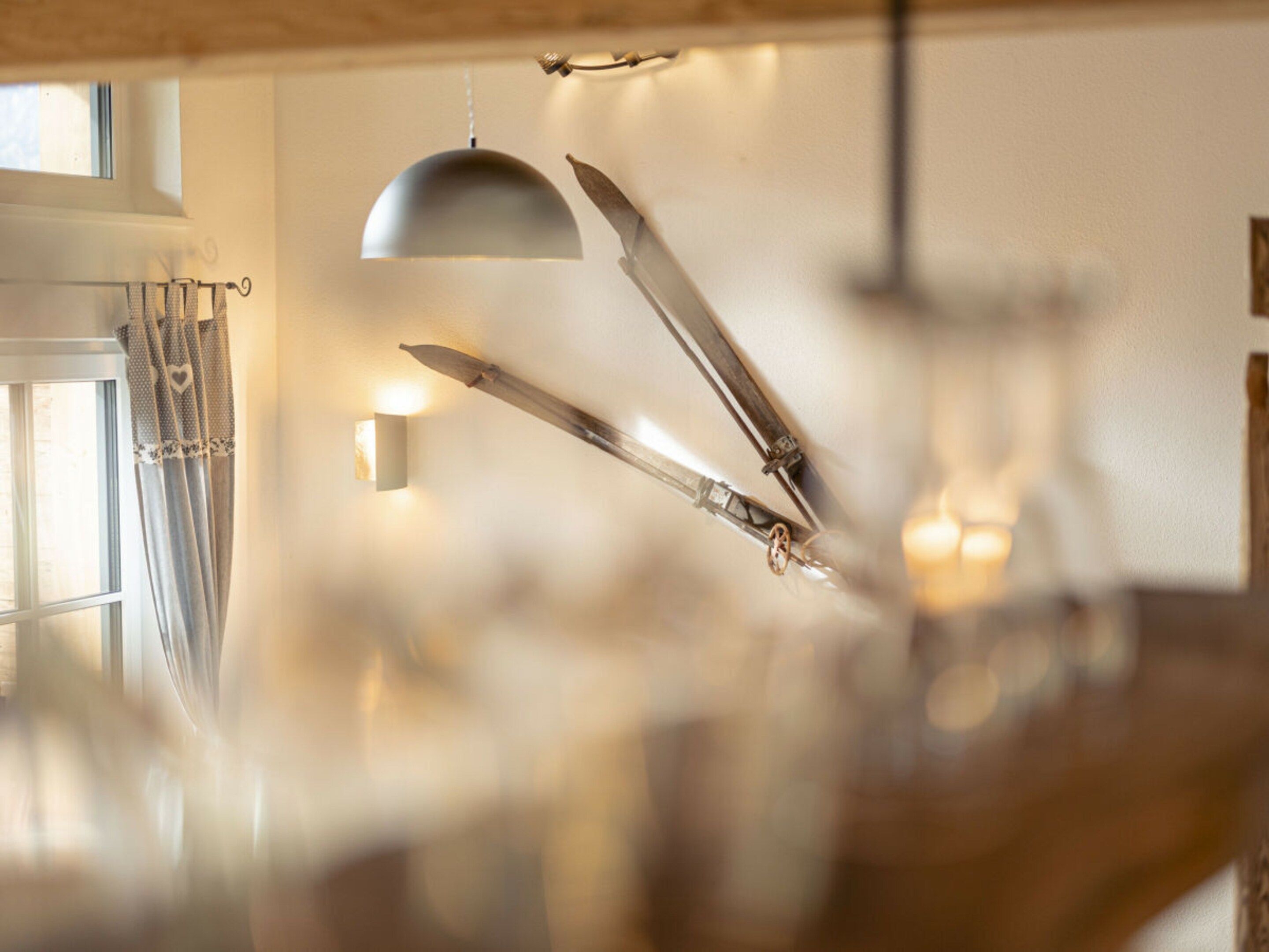 Une pièce avec une fenêtre, un luminaire suspendu et une applique murale.