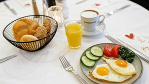 Ein Frühstückstisch mit Eiern, Gemüse und einem Glas Orangensaft.