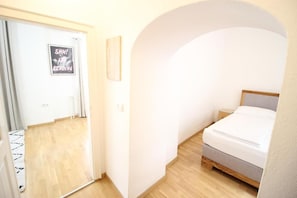 A bedroom with a bed, a nightstand, and a door with a sign. - Smarthotel Schmid (Sitzenberg)