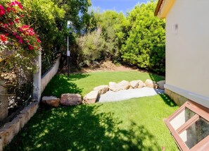 Un jardín cuidado con césped, un pequeño elemento de agua y un borde de piedra.