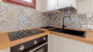 Una cocina con estufa, horno y un lavamanos moderno.