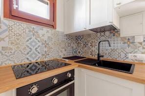 A kitchen with a stove, oven, and modern sink. - Villa Le Pavoncelle Home Holiday – Private Garden, 3 Bedrooms, Near the Beach (Eden Rock)
