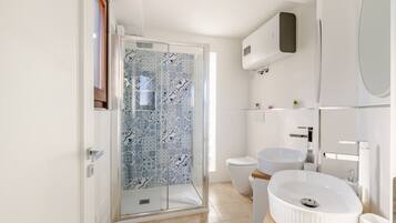 Une salle de bain avec douche, toilettes et lavabo.
