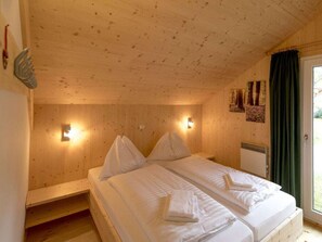 A wooden cabin bedroom with two beds, a wooden ceiling, and a window with curtains. - Cabin With 1 Bedroom (Sankt Georgen am Kreischberg)