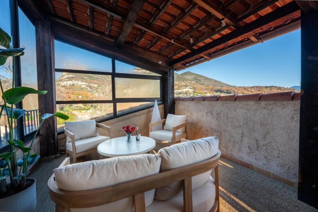 Una terrazza affacciata su un paesaggio collinare, arredata con un divano, sedie e un tavolino.