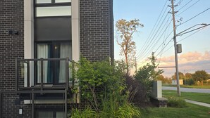 En modern byggnad med en fasad av tegel, ett stort fönster och en grind av metall.
